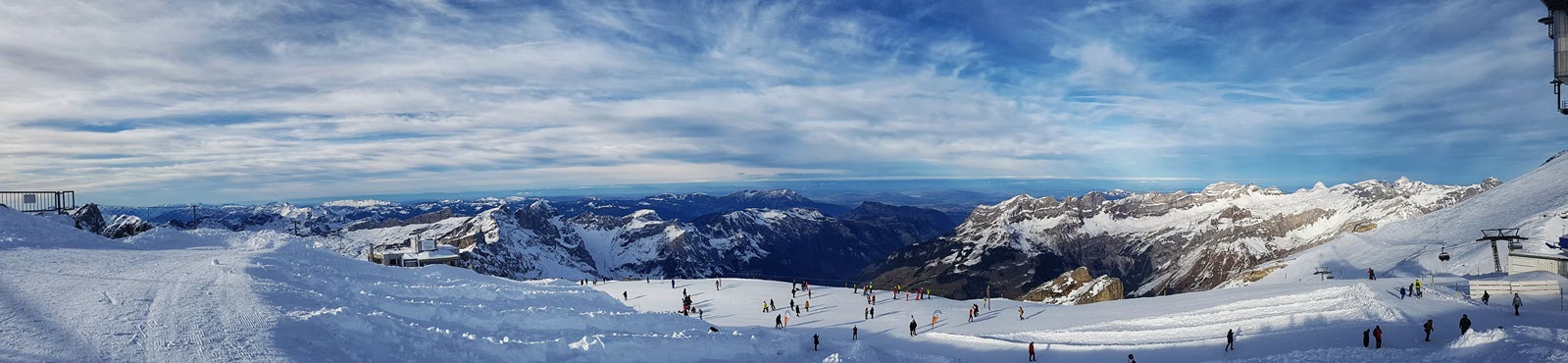 Panorama view from Mount Titlis showing skiers on a Swiss Alpine Slope